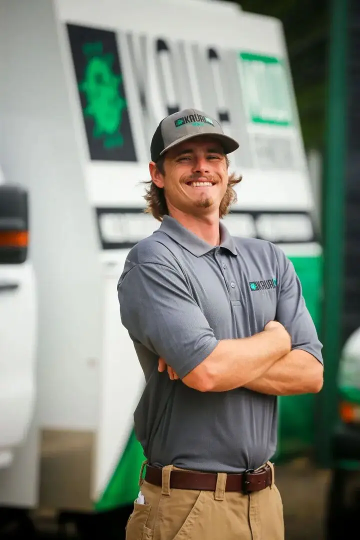 A man standing in front of a truck with his arms crossed.